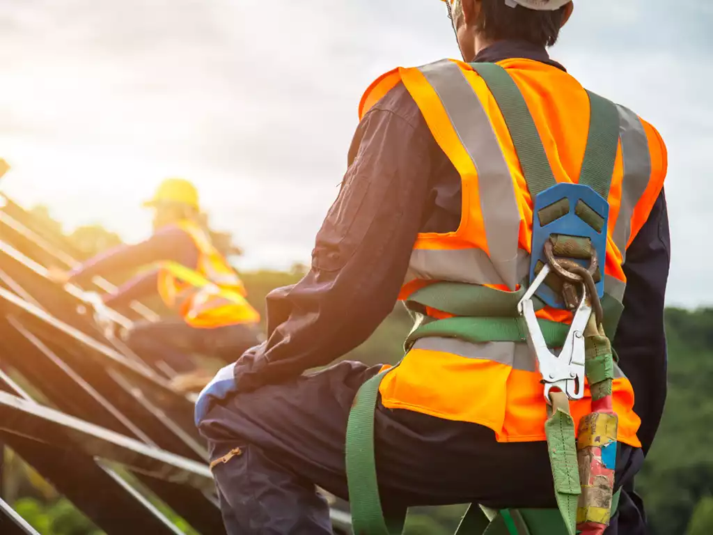 construction worker with fall arrest on looking on the unfinished roof